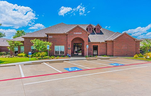 a brick building with a basketball court and a parking lot